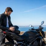 homme moto garée bord de mer