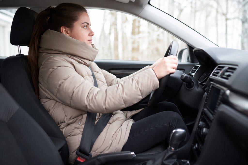 femme conduisant sa voiture avec une doudoune