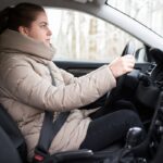 femme conduisant sa voiture avec une doudoune