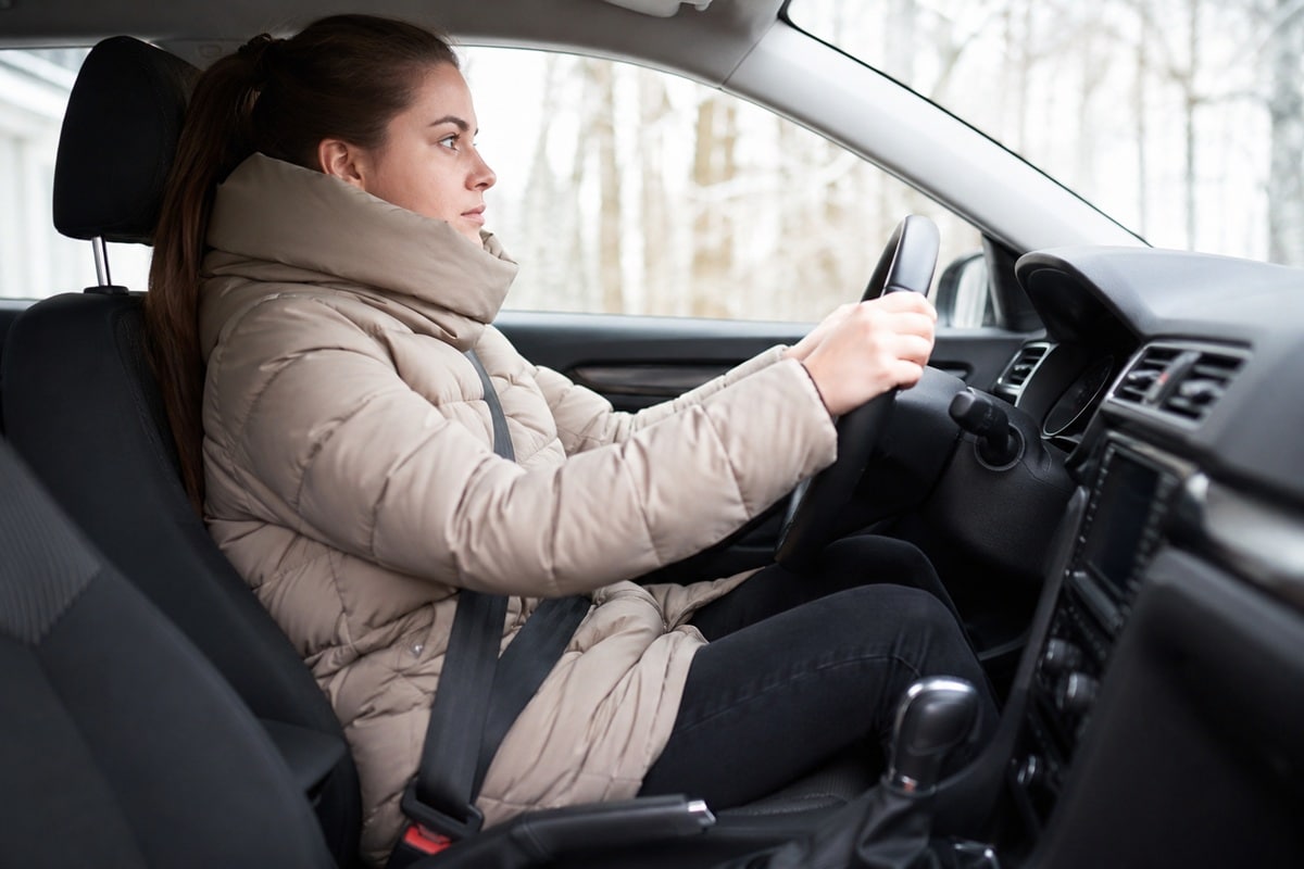 femme conduisant sa voiture avec une doudoune