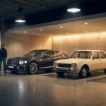 Deux hommes dans un garage moderne devant une Bentley moderne grise et une Peugeot 504 blanche vintage.
